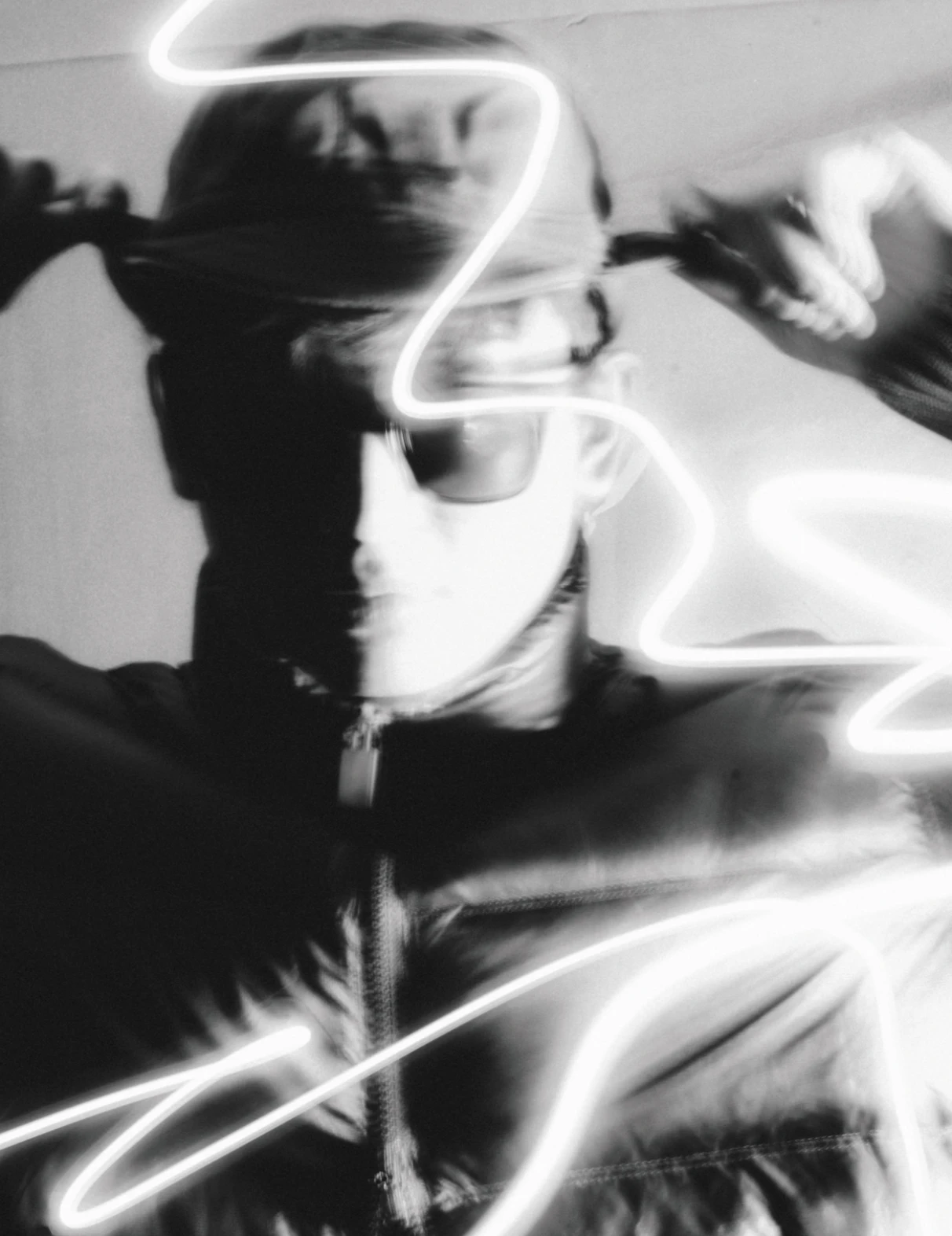 A blurred black-and-white portrait crossed by streaks of light
