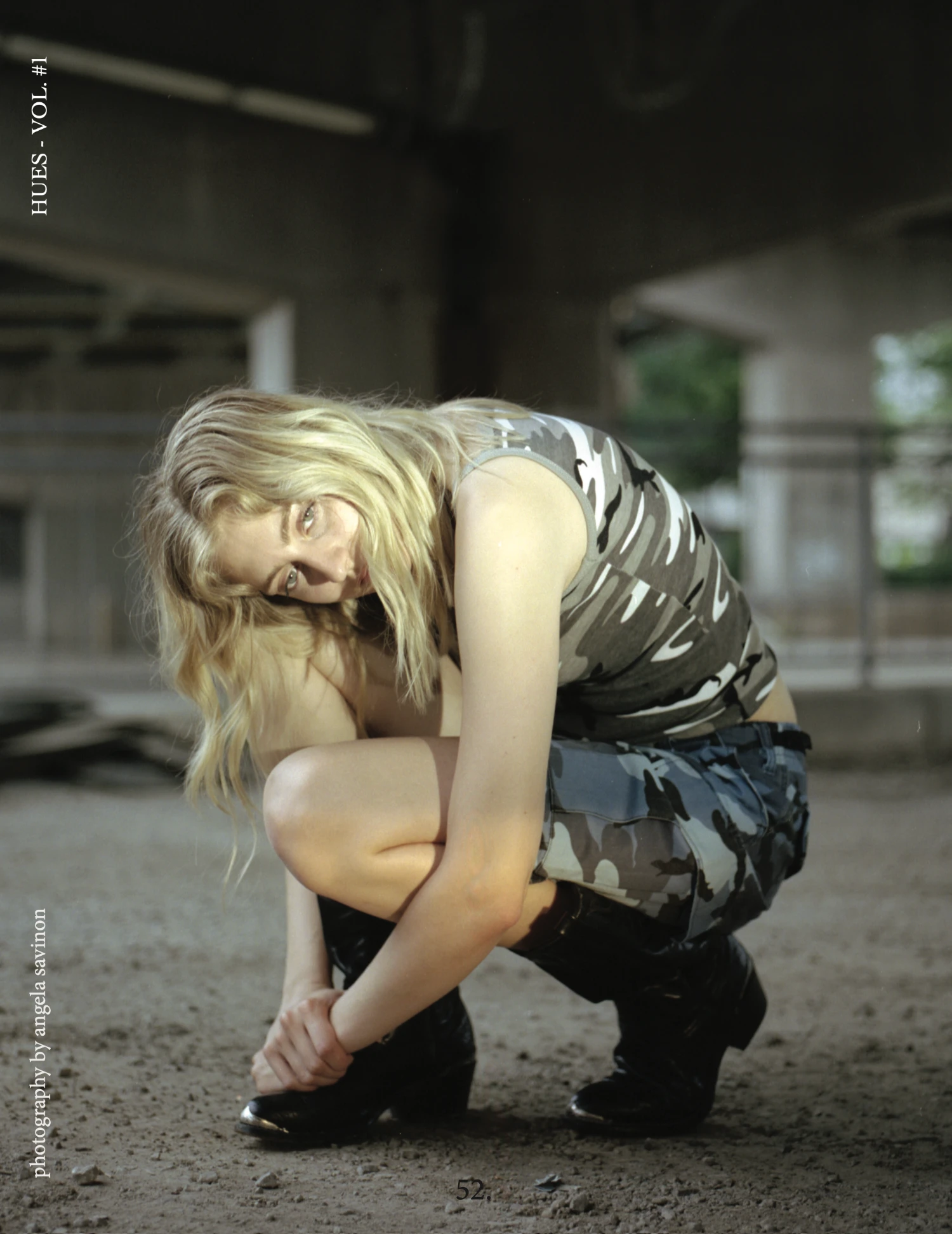 Hues Magazine cover featuring a woman crouching in a concrete interior