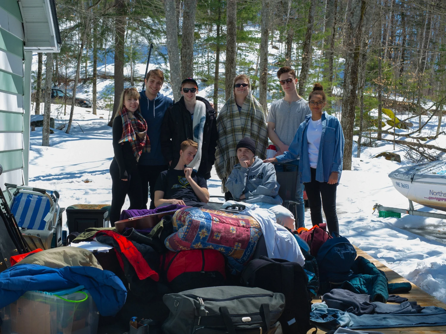 A group gathered behind a couch on a snowy outdoor set