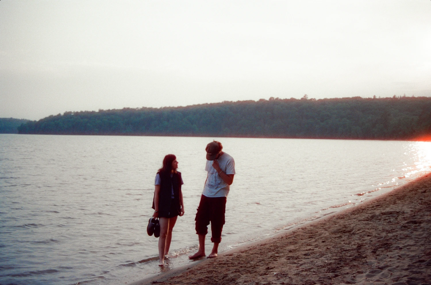 A couple walking along the beach at sunset